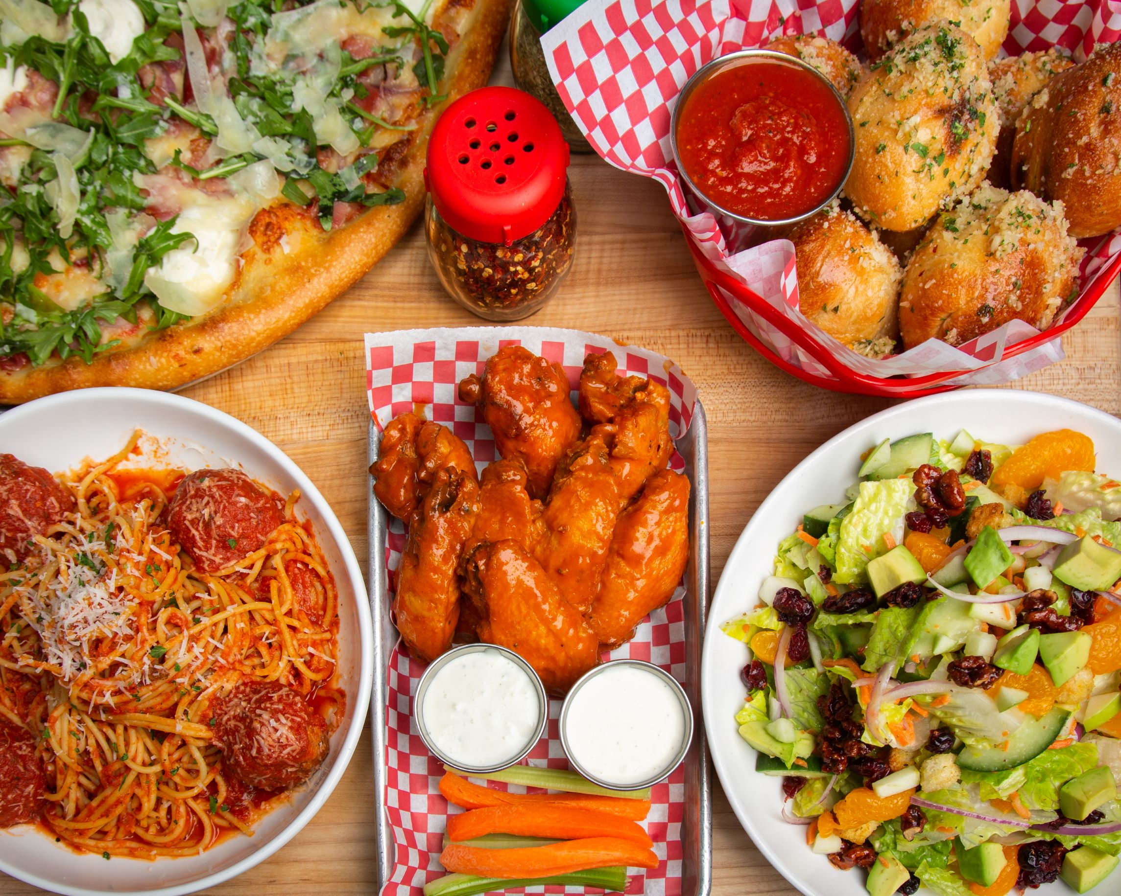 Slice of Vegas photo with pizza, garlic knots, wings, salad and spaghetti and meatballs